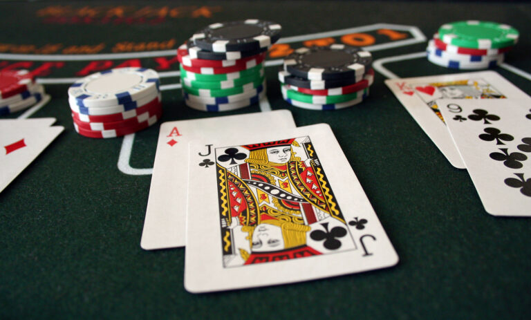 Blackjack table with some poker chips and a hand showing ace of diamond and jack of clubs